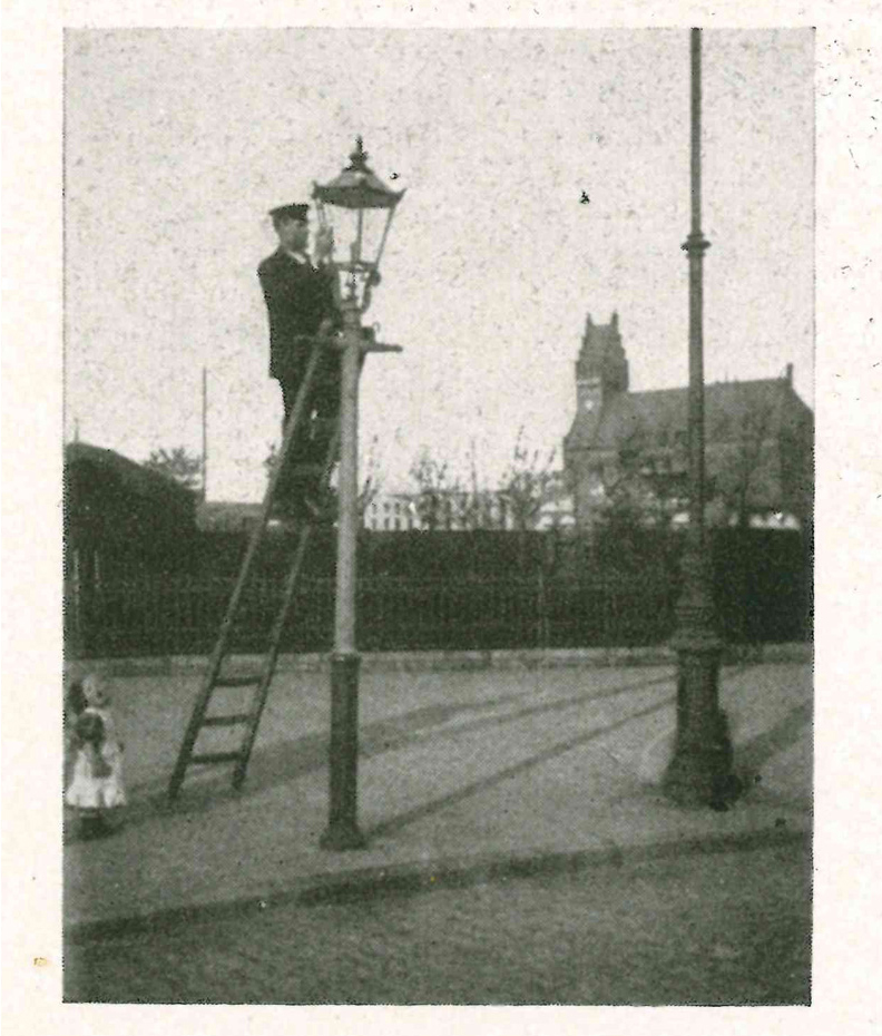 historische Aufnahme: Ein Lampenwärter inspiziert eine Gaslampe.